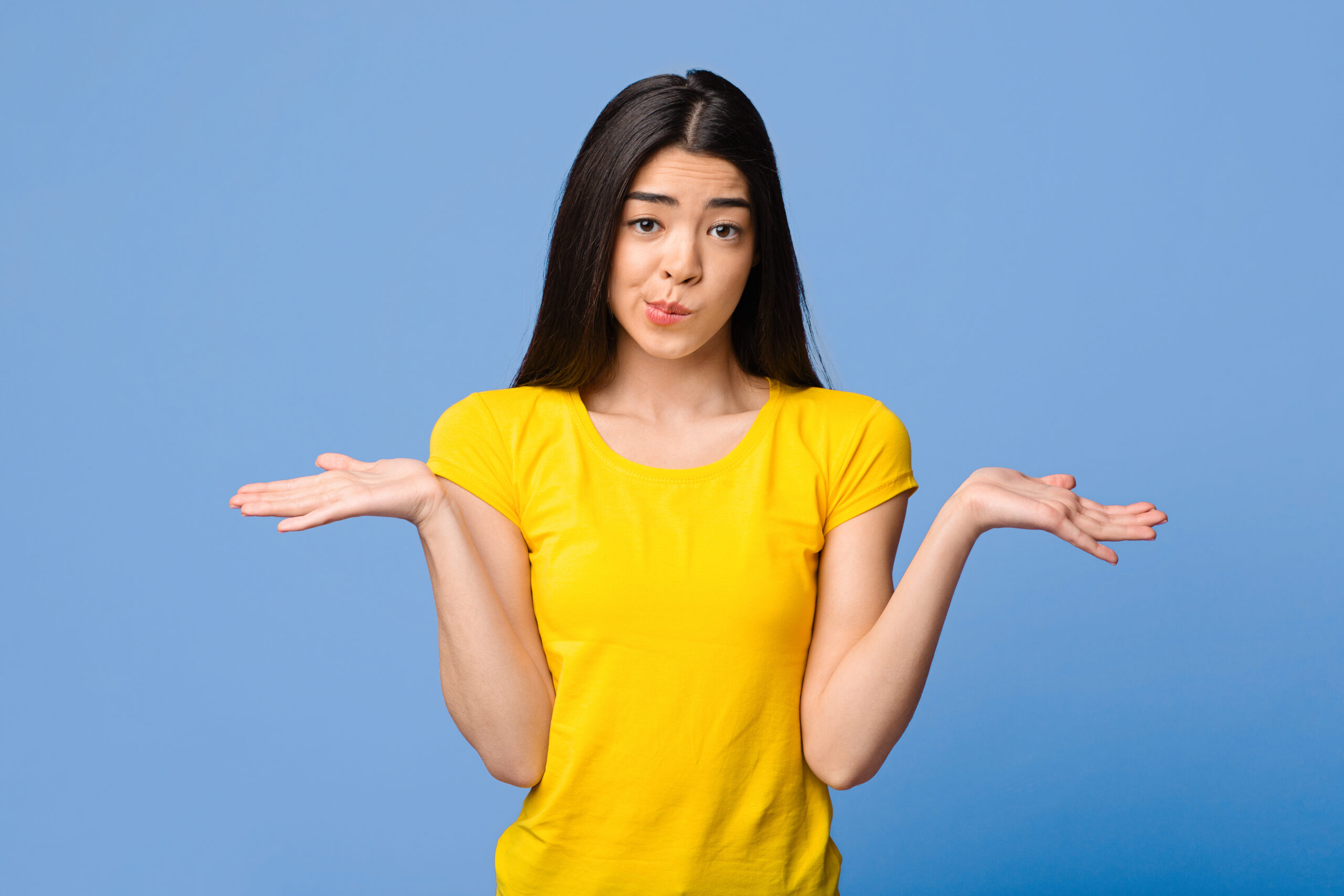 I Don’t Know. Careless Asian Girl Shrugging Shoulders Over Purple Studio Background