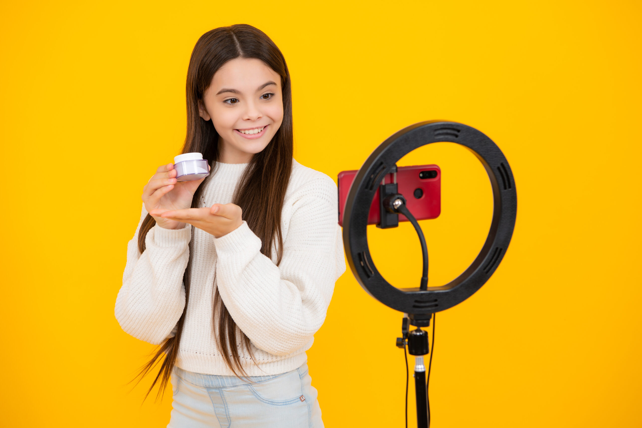 Beauty blog, presenting makeup cosmetics powder and brush. Teen girl speaking in front of camera for vlog. Teenager working as blogger, recording video tutorial for blog.